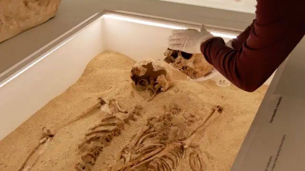 What did researchers discover about the two skeletons buried in Romito Cave<br><br>