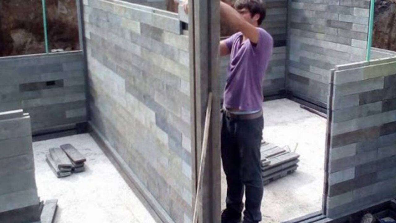 A worker assembles blocks made from recycled plastic to build a house in Colombia.