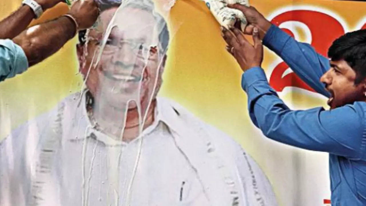 Supporters of Siddaramaiah pour milk on his poster in Bengaluru on Wednesday