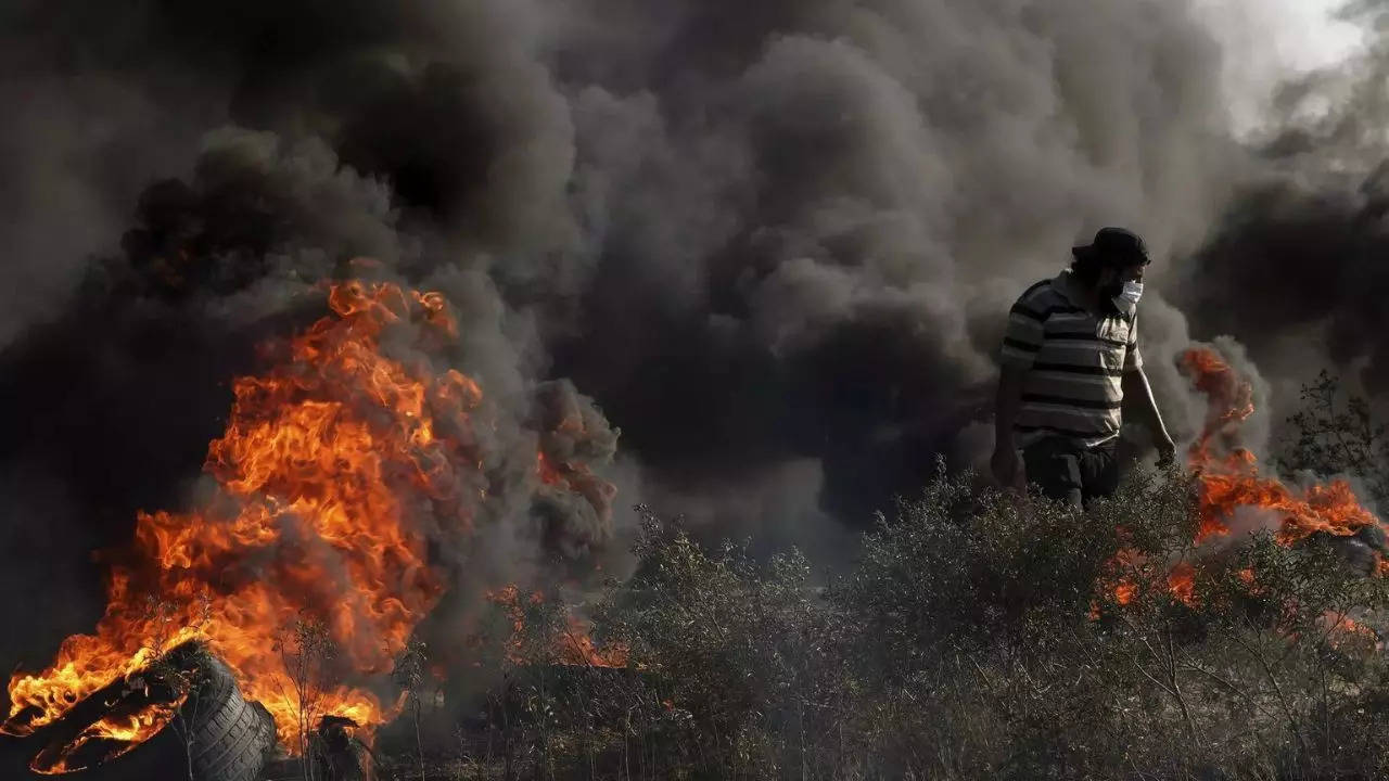 A Palestinian protester burns tires during clashes with Israeli security forces along the frontier with Israel, east of Gaza City, Friday, Sept. 22, 2023. (Photo by AP)