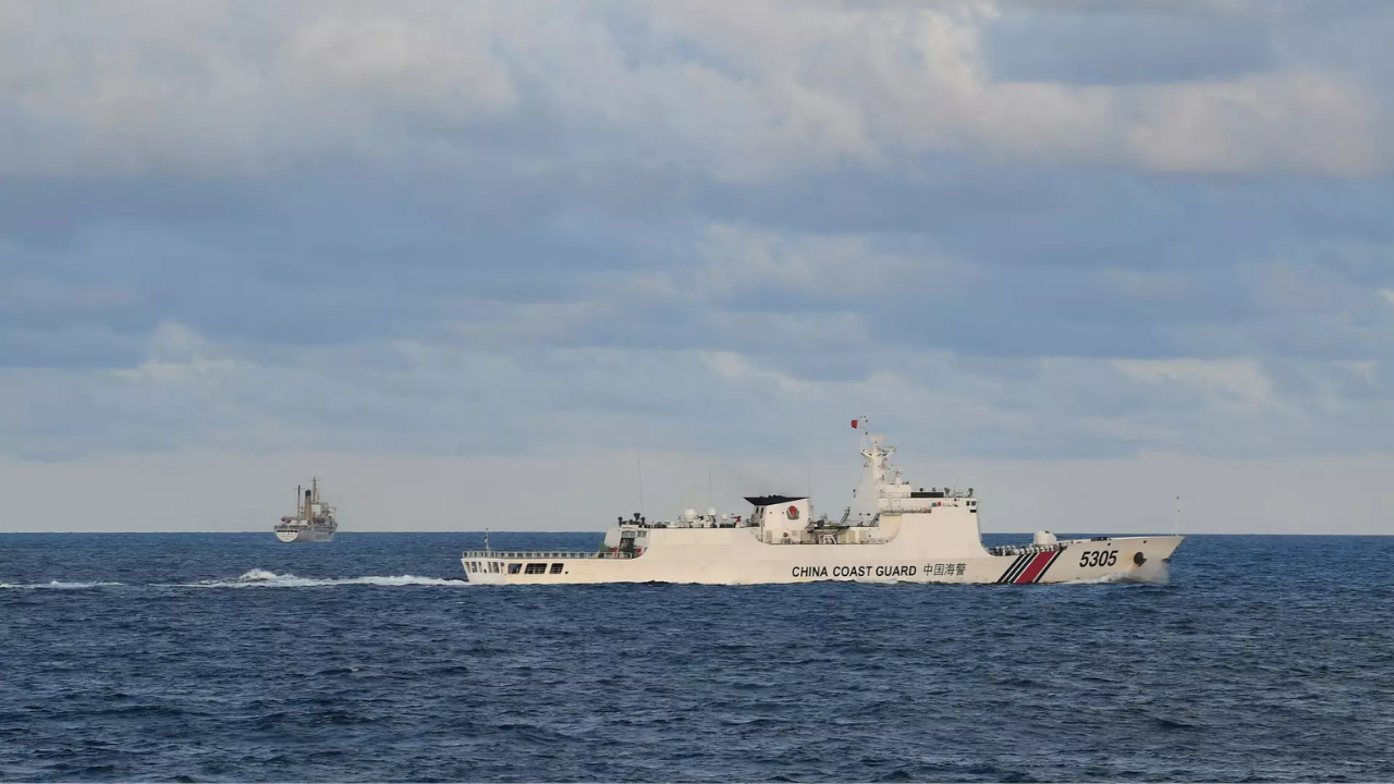 A Chinese Coast Guard ship sails near a Philippine vessel (AFP)