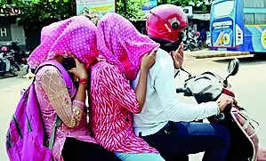 People cover their faces to beat the heat in Cuttack on Saturday