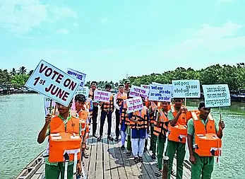 Poll officials take a boat ride to Batighar to urge islanders to vote