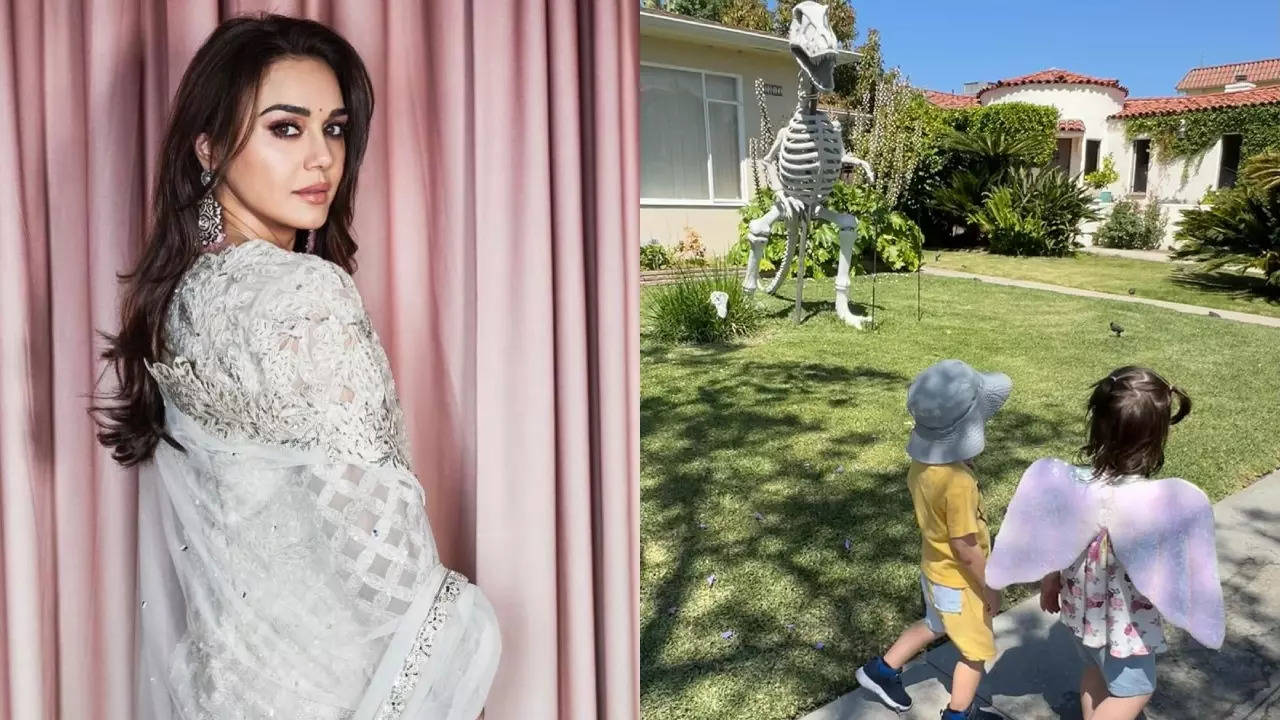 Preity 's twins are amused with a Dinosaur statue