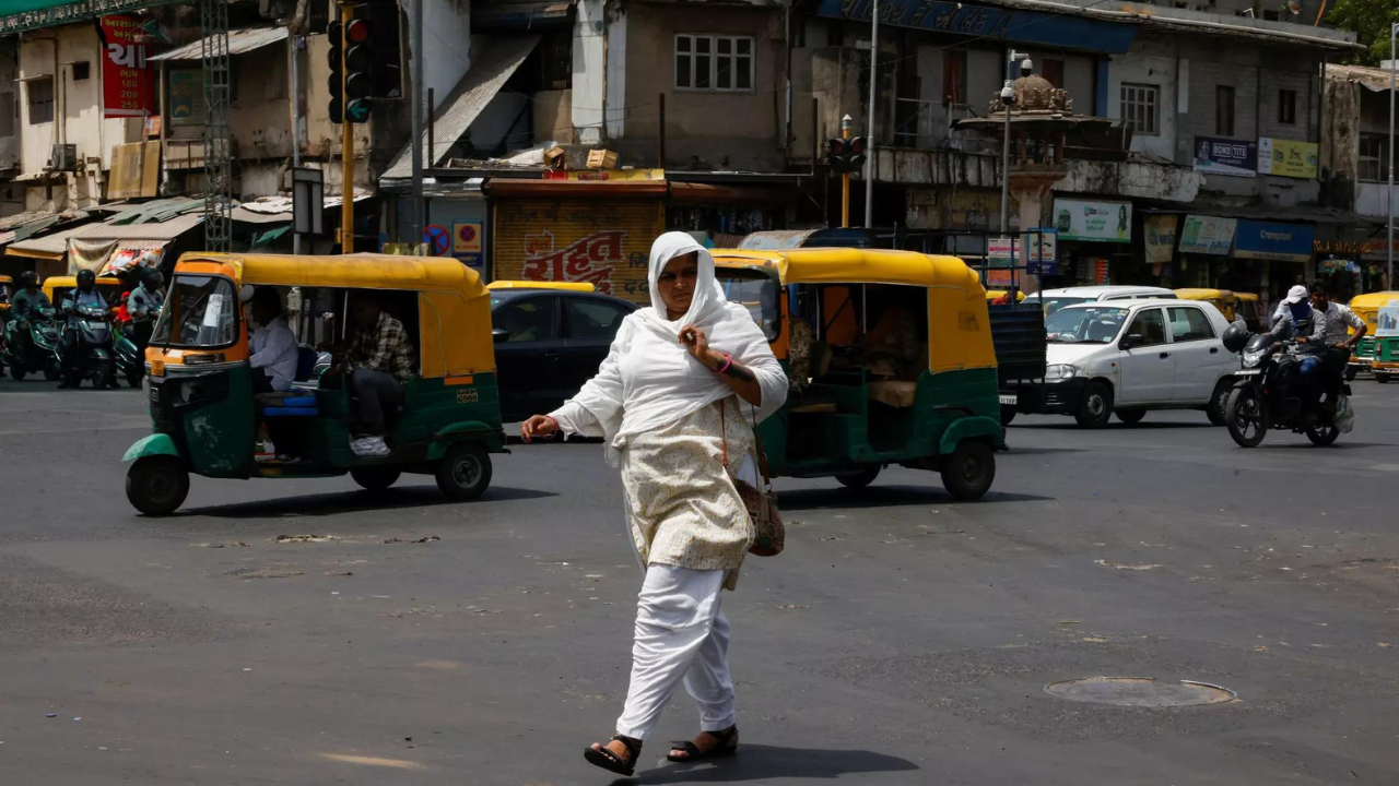 A woman covered with a cloth to protect herself from the heat walks on a road during a heatwave (Reuters photo)