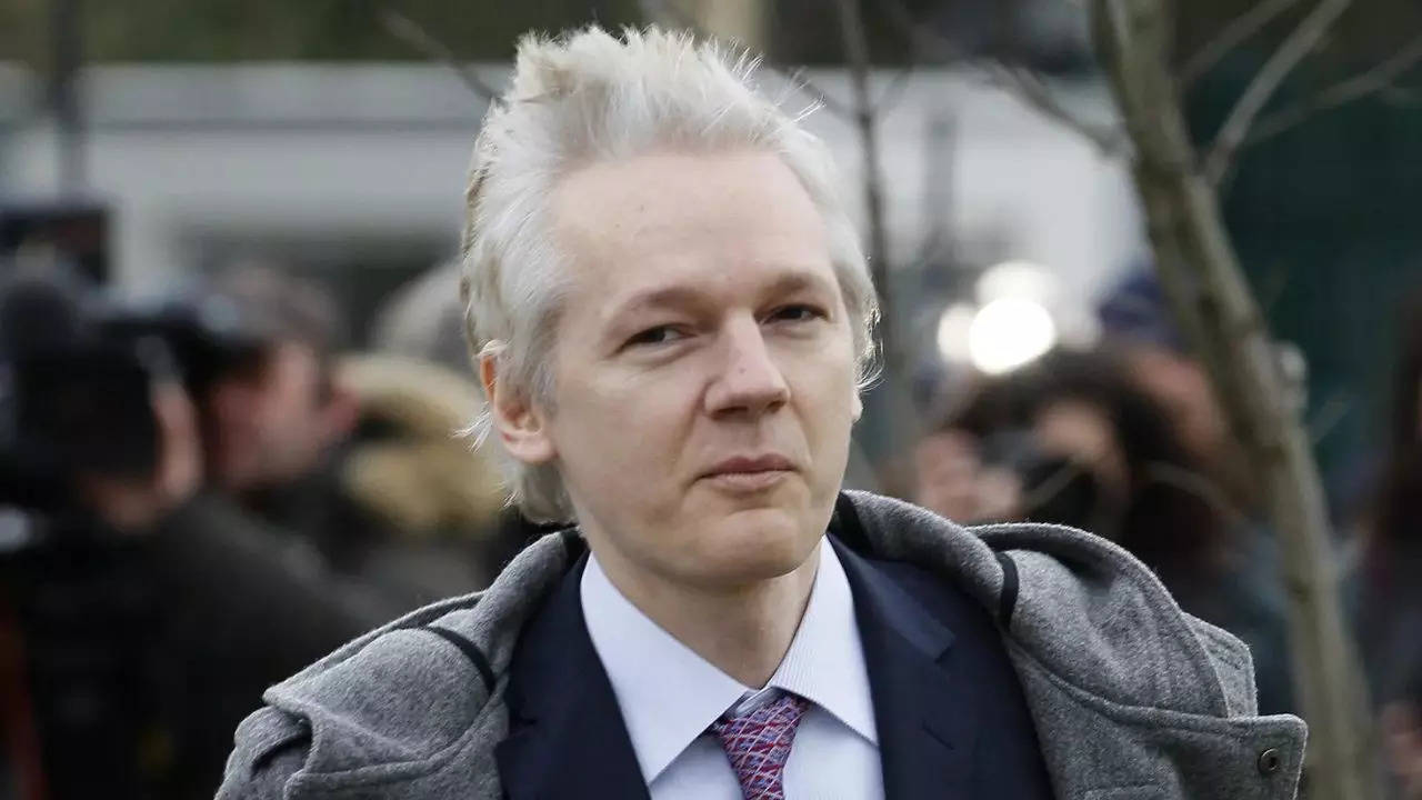 Why is Julian Assange flying to the remote Pacific island of Saipan?