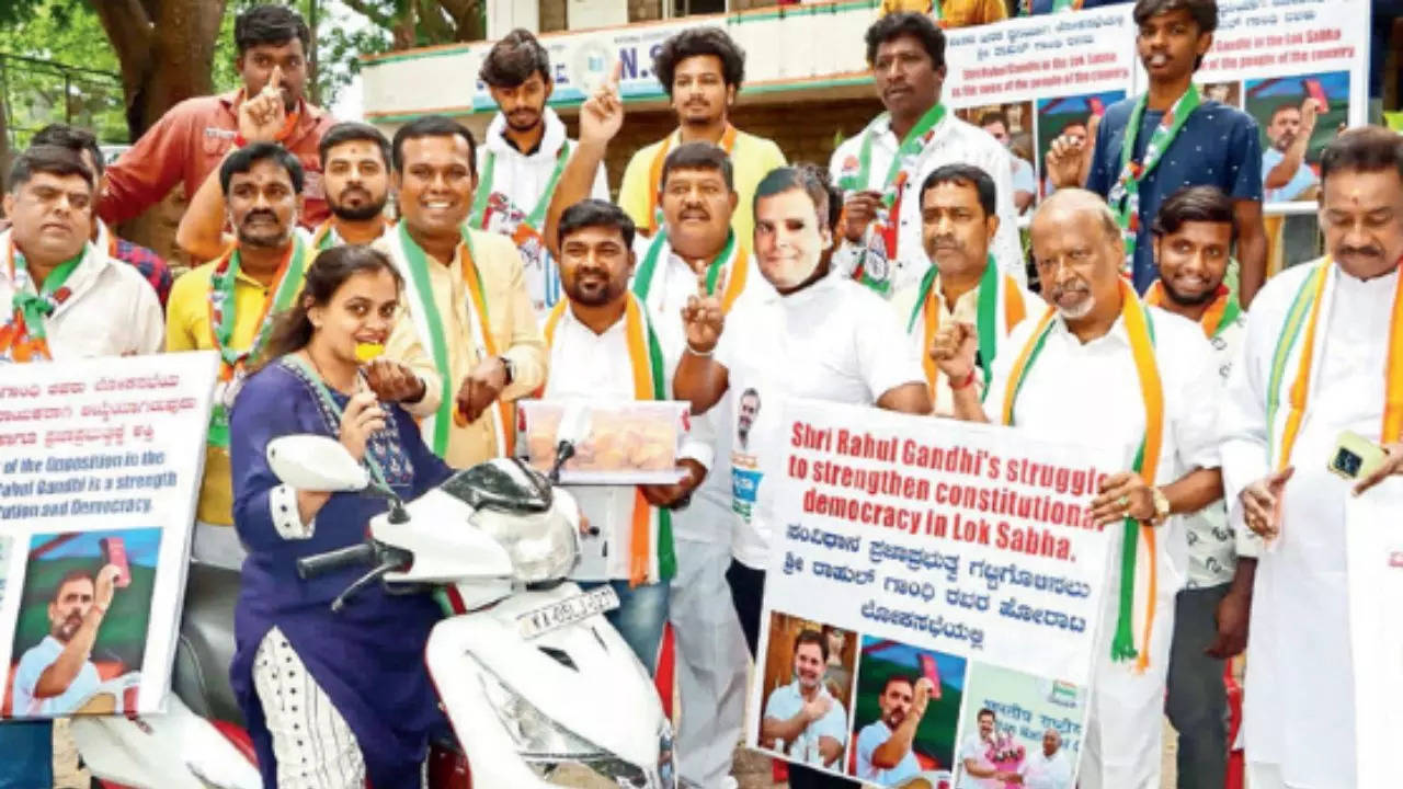 Bengaluru City Youth Congress members distribute sweets to people on Wednesday, after Rahul Gandhi was elected leader of the opposition in the Lok Sabha