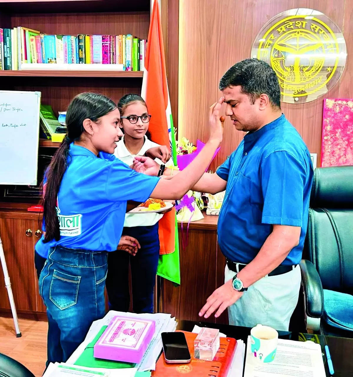 Green bond: Students tie rakhis made from recycled plastic on DM’s wrist