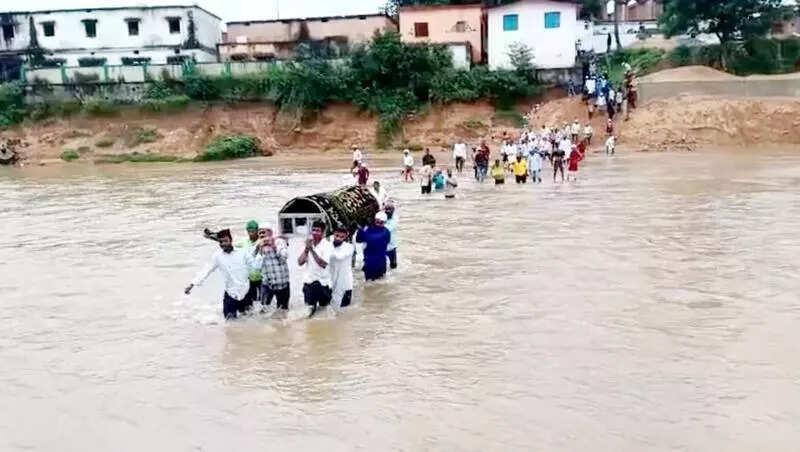 Villagers carry body in rain-fed river