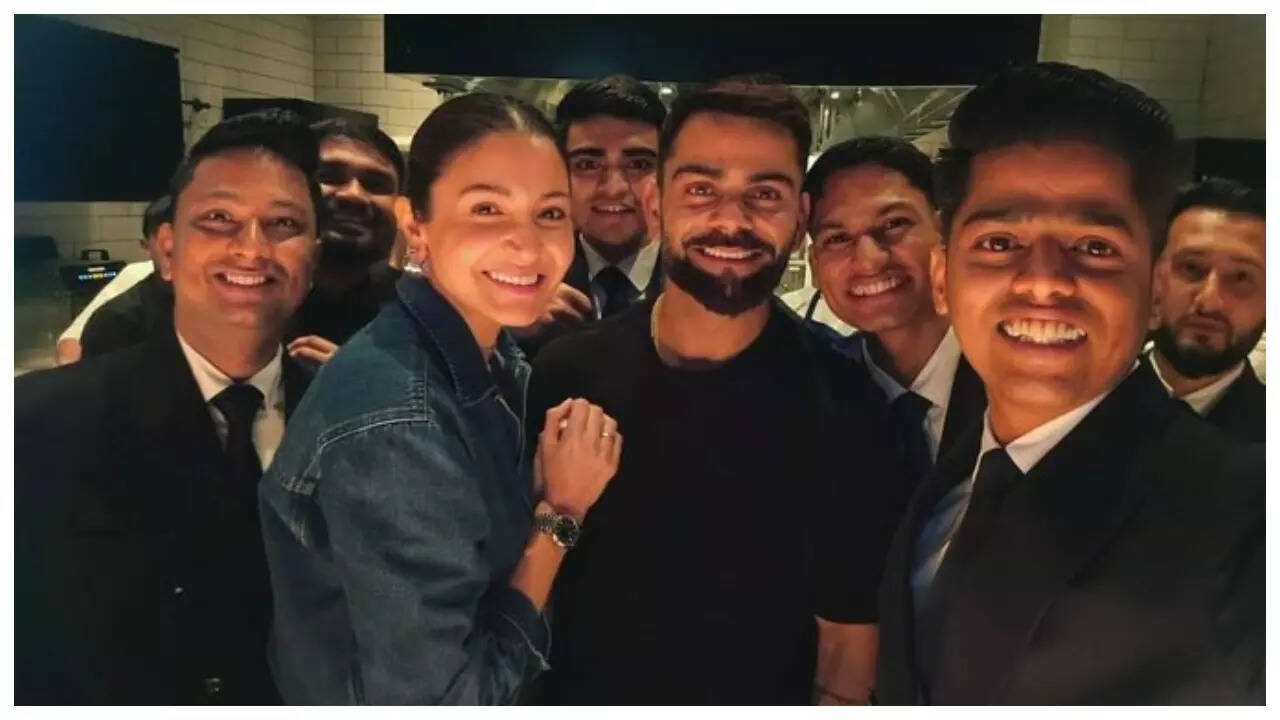 Virat-Anushka are all smiles as they pose with hotel staff- Pics