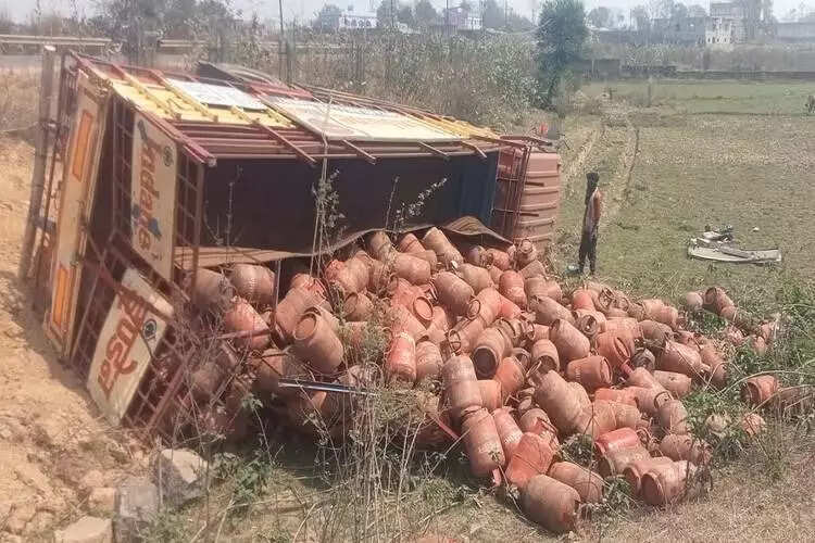 Truck carrying cylinders turns turtle