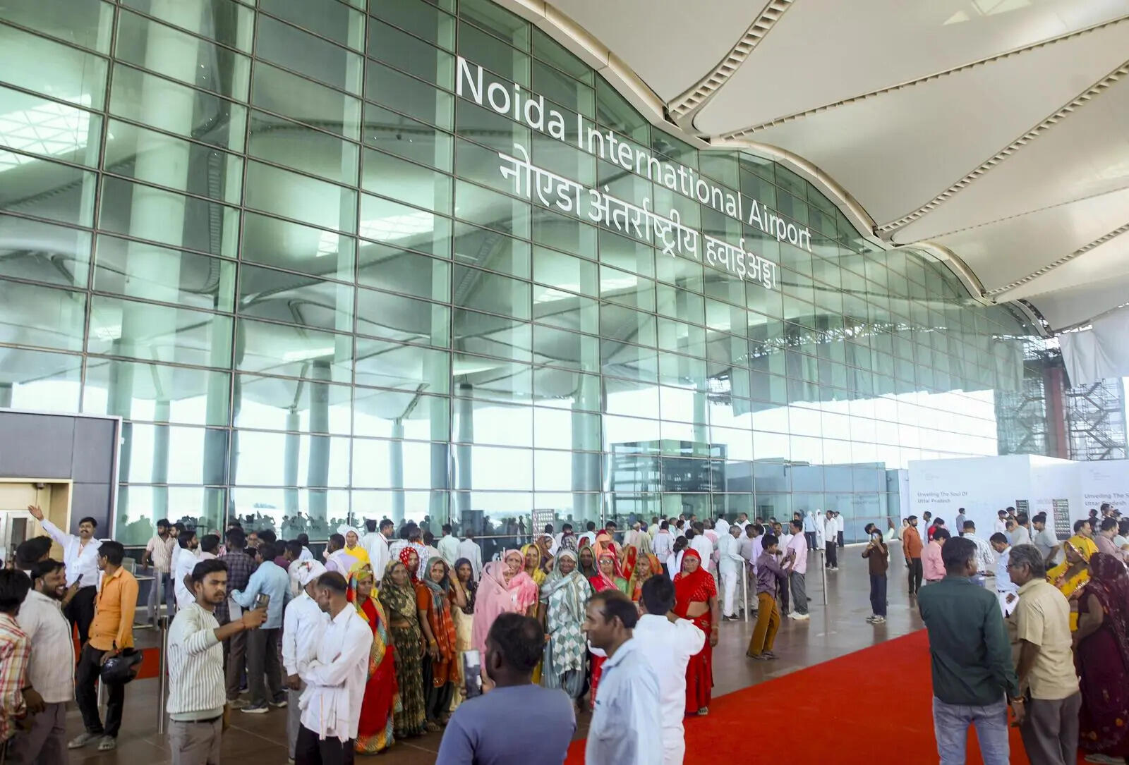People, many of them from Jewar villages, take selfies at the airport forecourt on Saturday