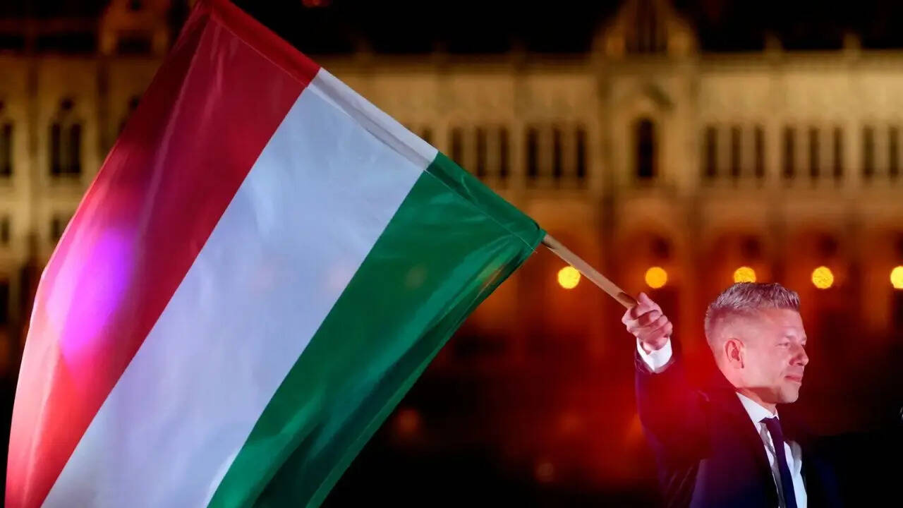 Peter Magyar, leader of the opposition Tisza party, waves the Hungarian flag following the announcement of the partial results of the parliamentary election
