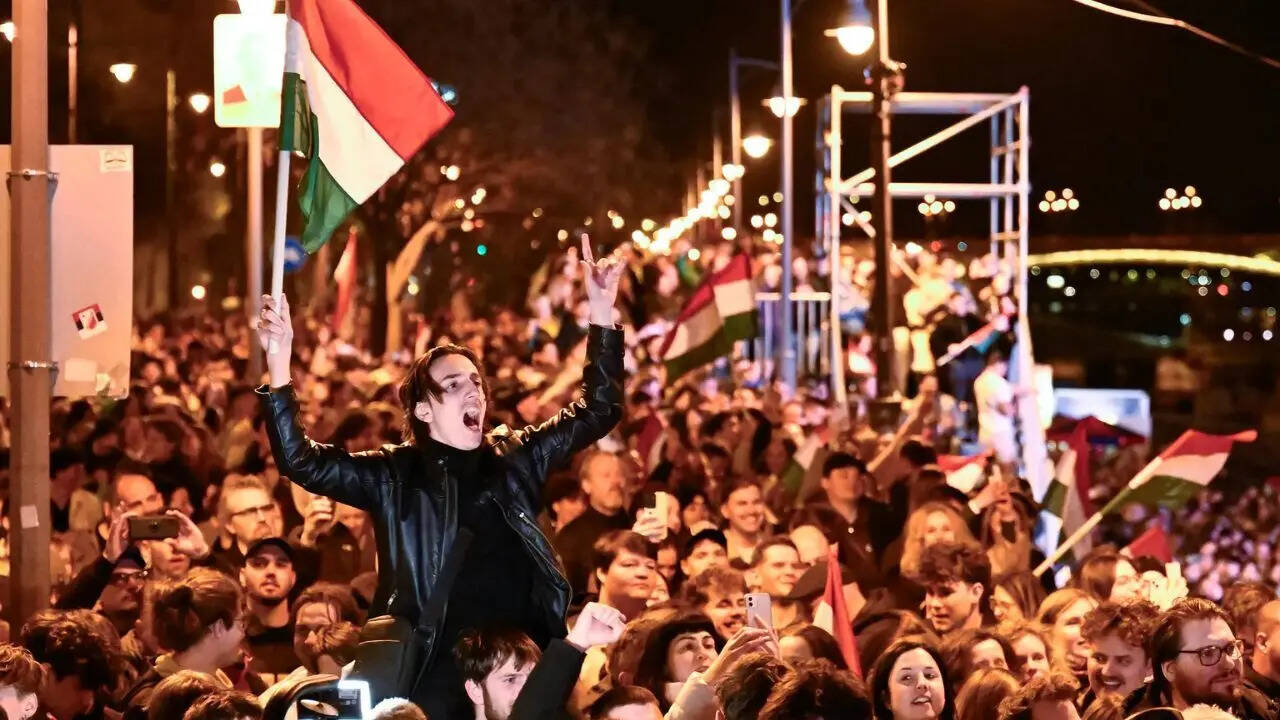 A man waves a Hungarian flag as he celebrates in the streets after the announcement of partial results of the Hungarian parliamentary election