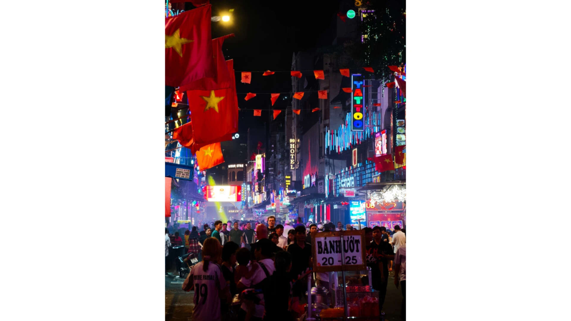 Crowded night street with flags