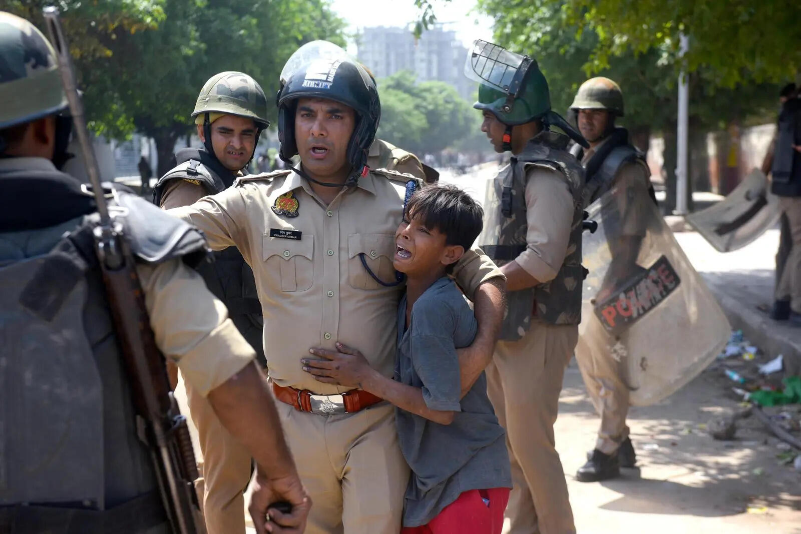 Police escort child to safety amid violence