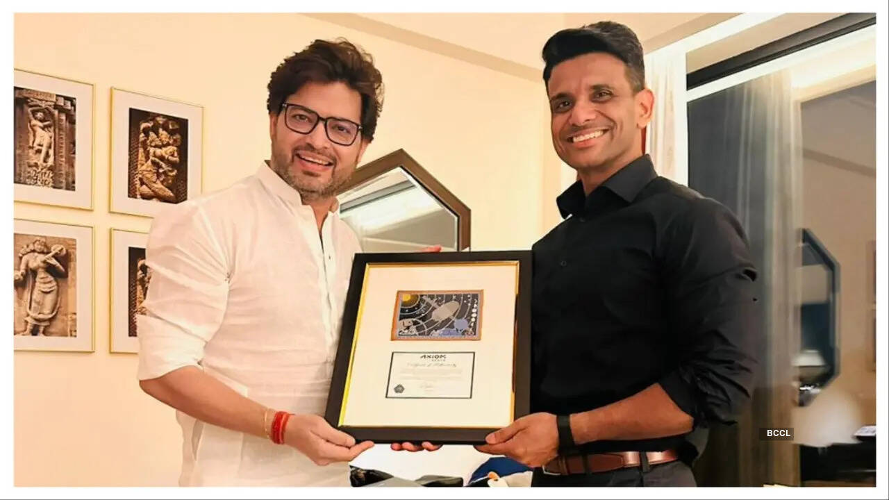 Shux presenting the mission patch to designer Manish Tripathi following its journey to space