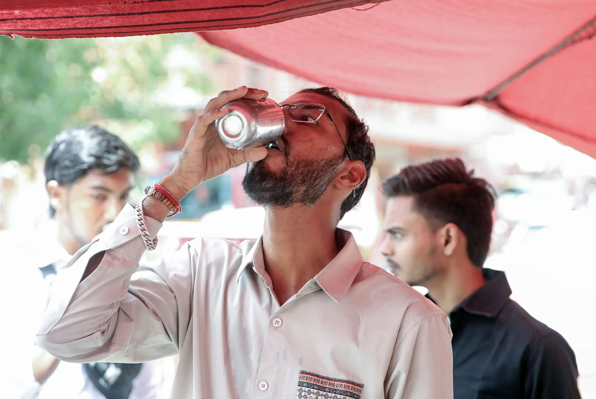 Amritsar, May 21 (ANI): A man drinks water offered by volunteers from a free wat...
