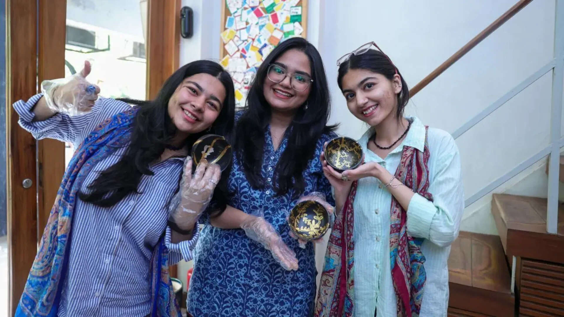 Attendees show off their creatively pieced bowls decorated with gold