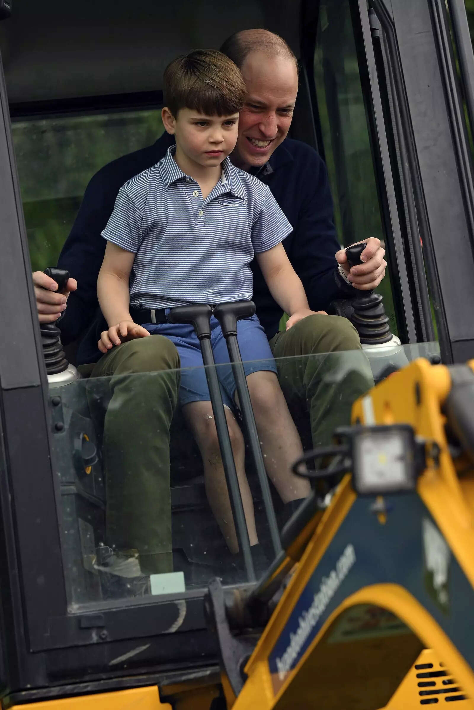 Britain's Prince William is helped by Prince Louis
