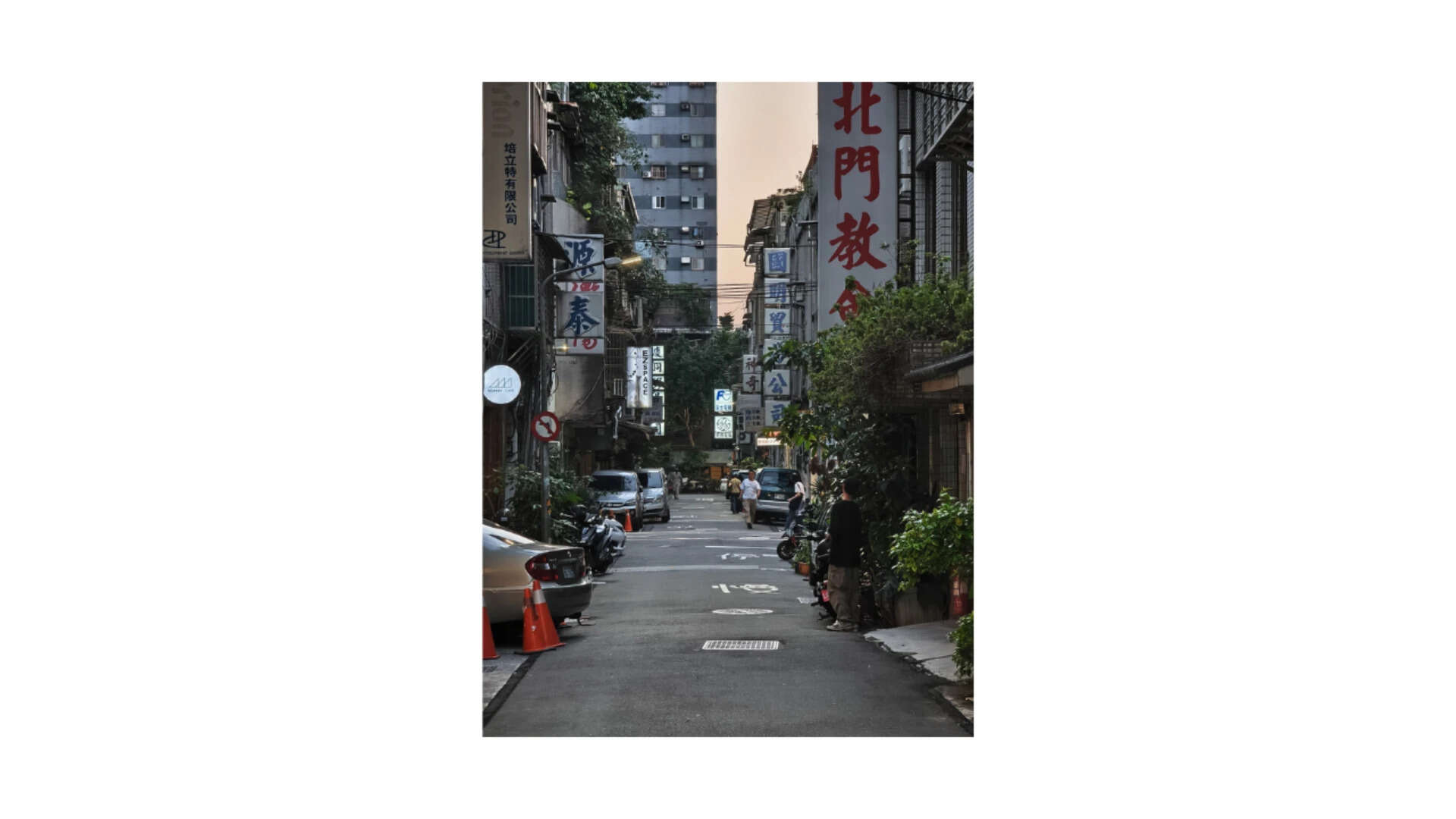 The 115mm flattening the street into stacked layers of signage and shopfronts.