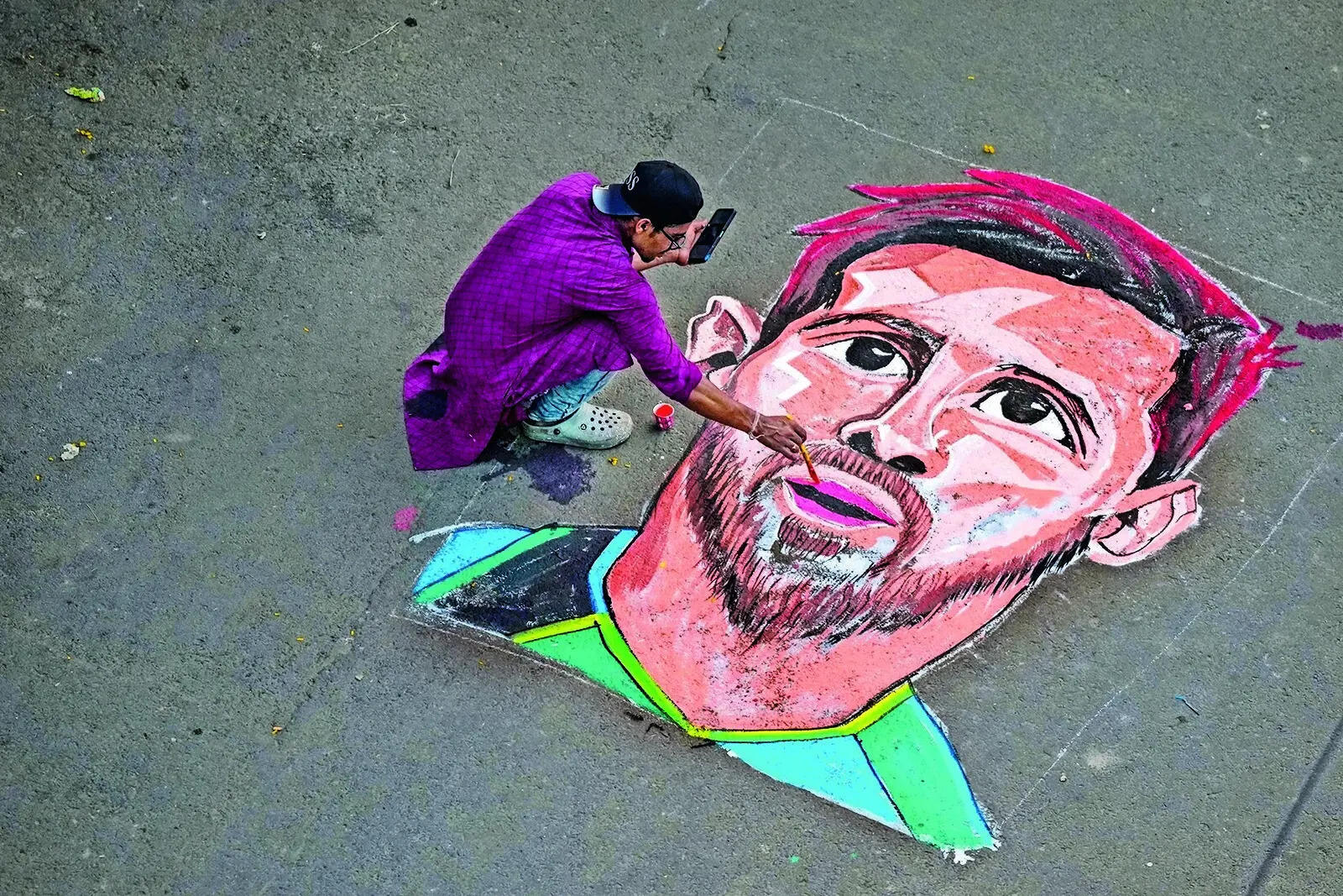 An artist paints portrait of Messi on a street in Patuli An artist paints portrait of Messi on a street in Patuli
