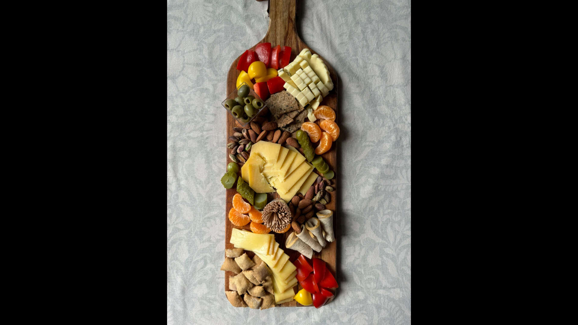 Cheeseboard showing off its vibrant side with aged cheddar, white cheddar, young Gouda, olives, and fresh fruits. IMG_1899