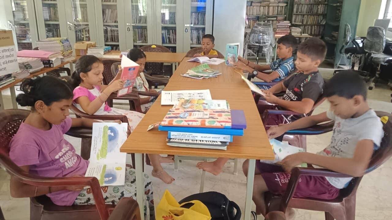 Rural children read books at an Arivu Kendra (village library) in a gram panchayat in Karnataka. Image - 2026-07-02T210625.635.jpeg