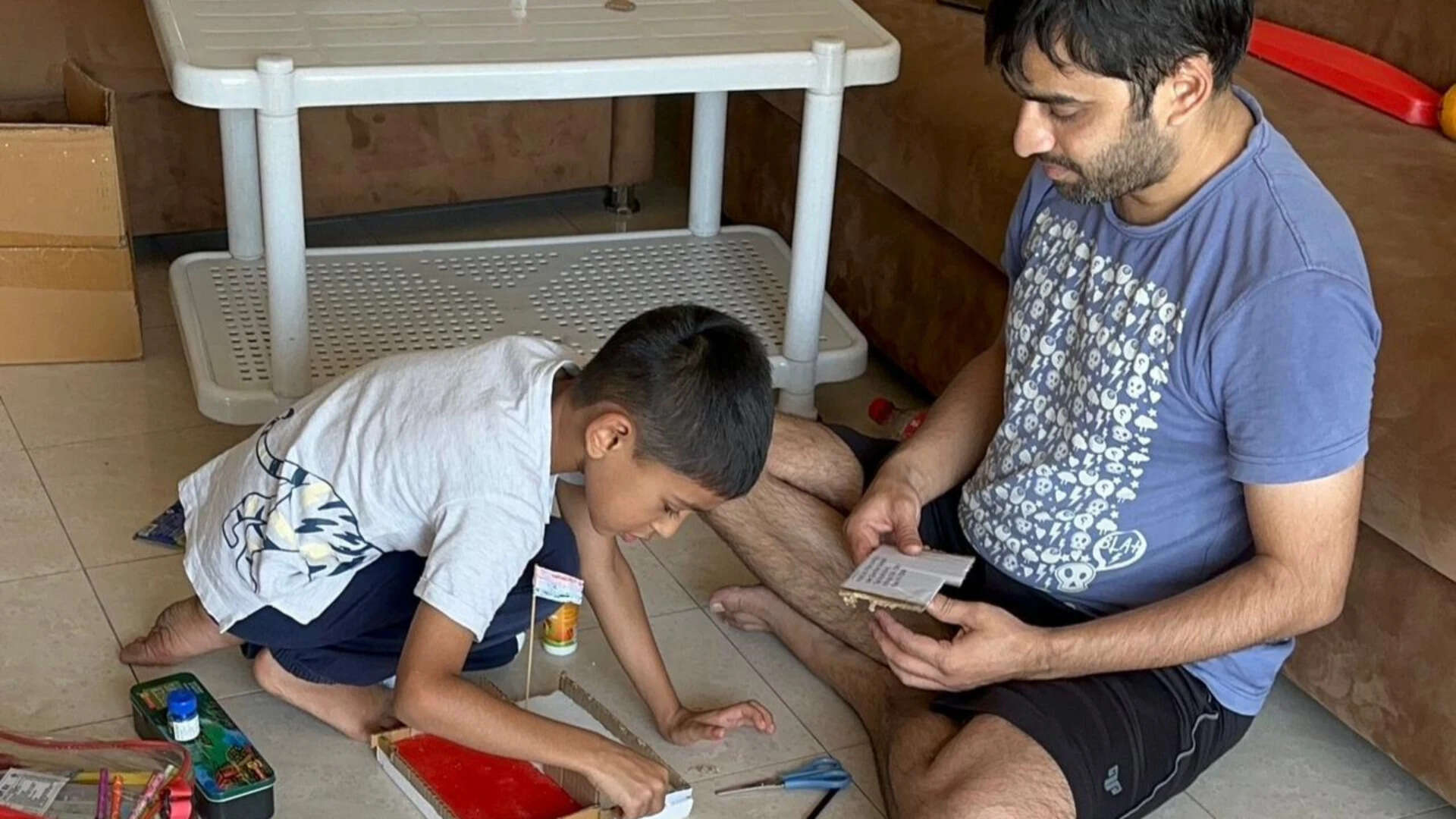 Young vedarth doing craft activities with his dad.