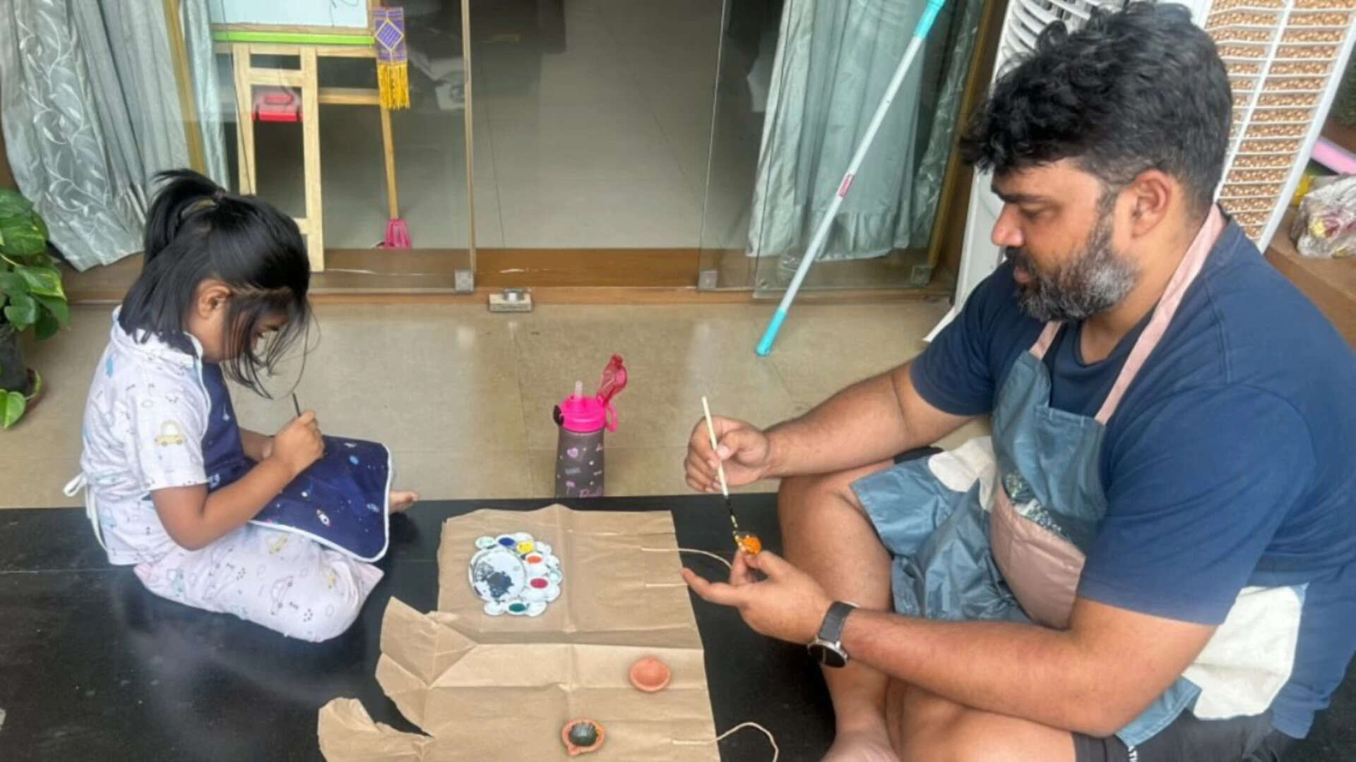 Shivani Bansal's husband and their daughter doing art and crafts activity together.