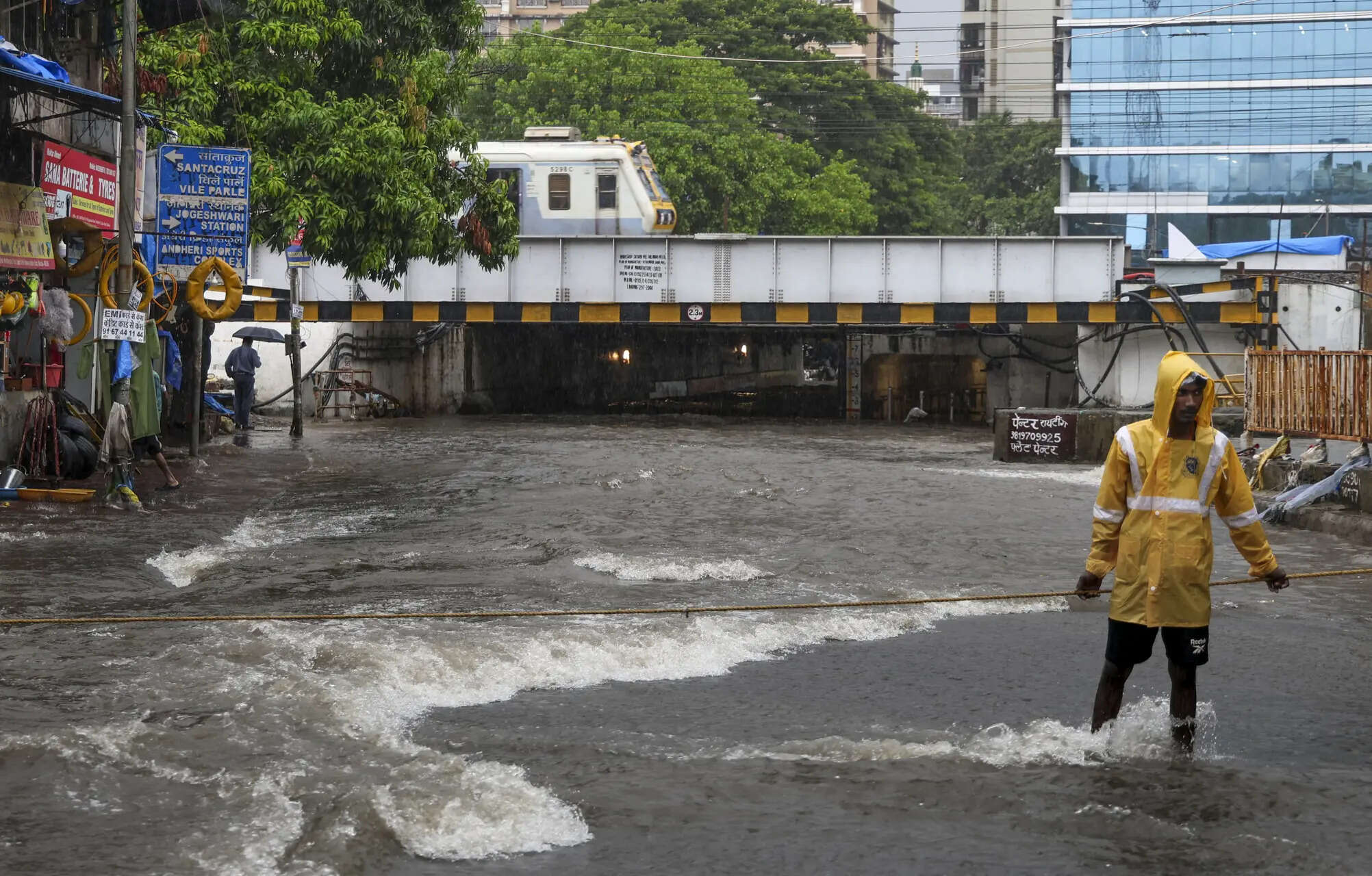 A person stands amid the waterlogged area near the Andheri subway after heavy rain, in Mumbai. (PTI Photo) Rain in Mumbai