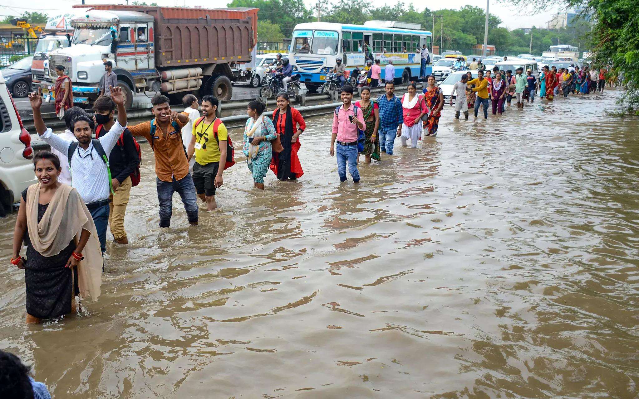 People wade through waterlogged service road of the Delhi-Gurgaon Expressway