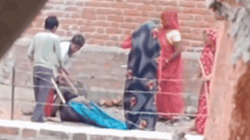 Woman thrashed with sticks in front of police, dies