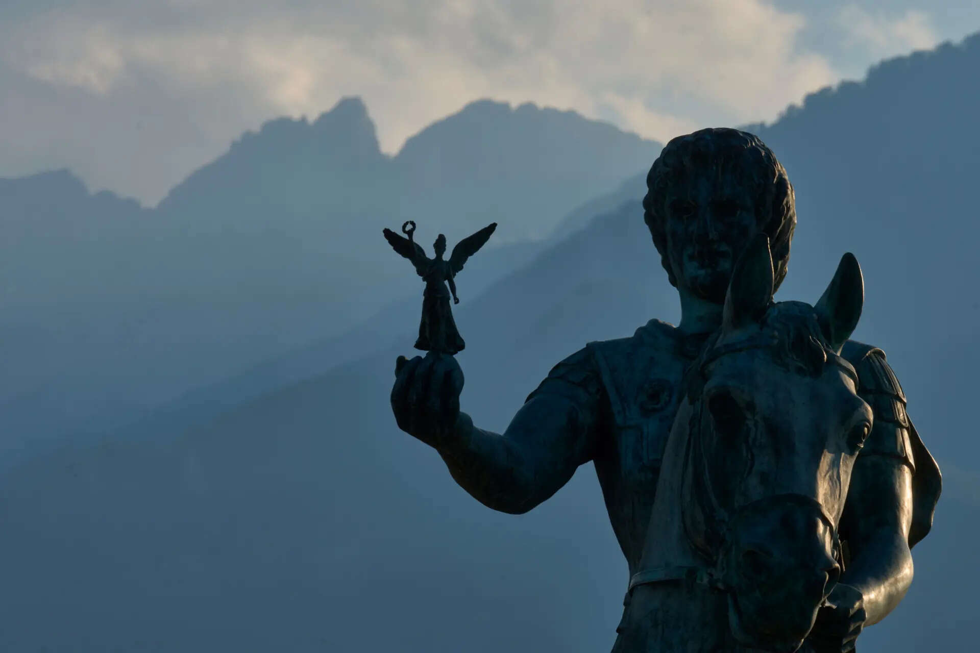 A statue of Alexander the Great holding Nike, the Greek goddess of victory, stands near Litochoro in northern Greece, Tuesday, July 14, 2026, backdropped by Mount Olympus' highest peaks, Mytikas and Stefani. (AP Photo/Petros Giannakouris) APTOPIX Greece UNESCO Mount Olympus