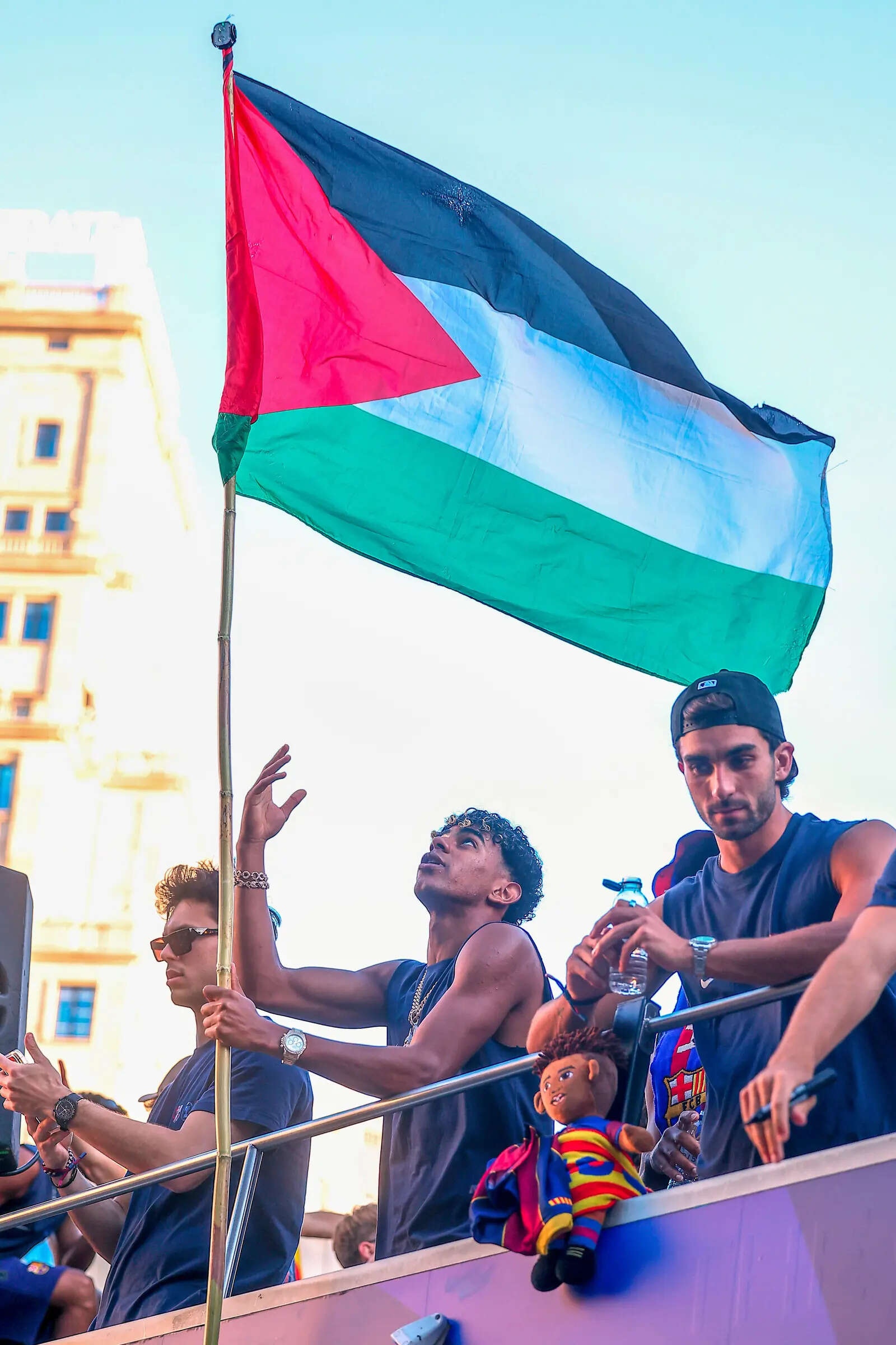 FILE - FC Barcelona player Lamine Yamal holds a Palestinian flag as he celebrates with his team atop a bus after winning the Spanish La Liga title in Barcelona, Spain, May 11, 2026. (AP Photo, File) Yamal holding the Palestine flag in May 11