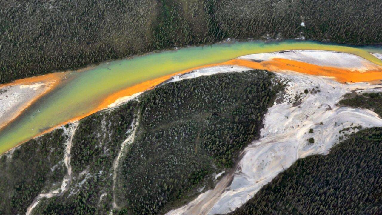 Orange stream water mixing with clear water