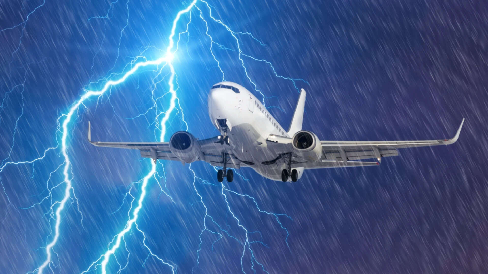 Lightning hits strike during a heavy downpour, behind a flying plane