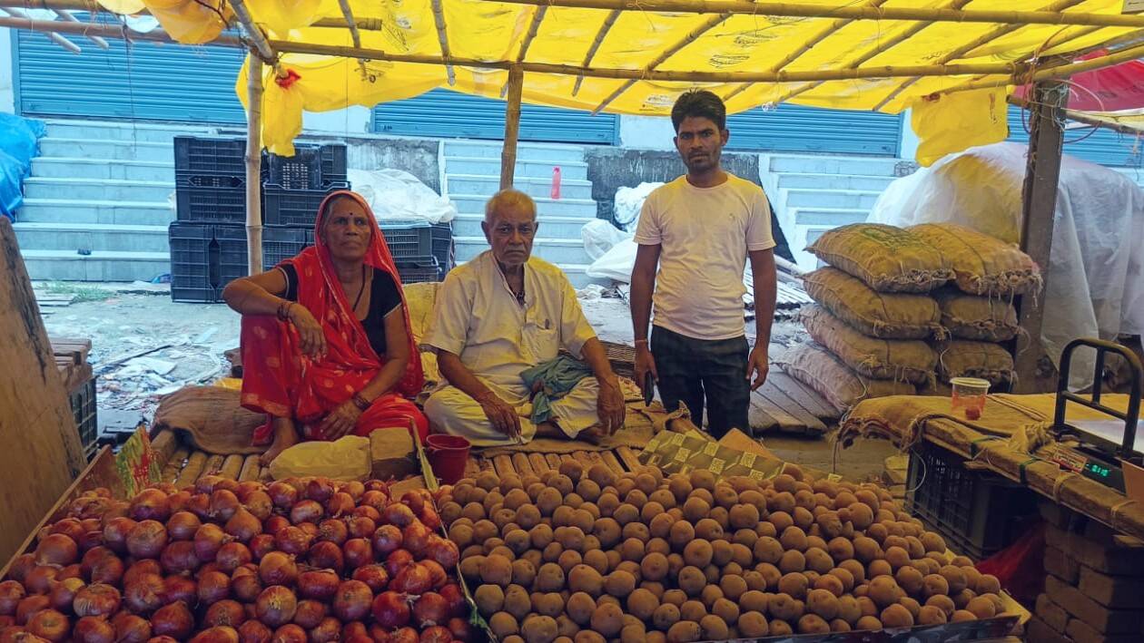 ઝંડુ કુમારના માતા-પિતા તેમના ભાઈ કુંદન સાથે તેમની શાકભાજીની દુકાન પર.