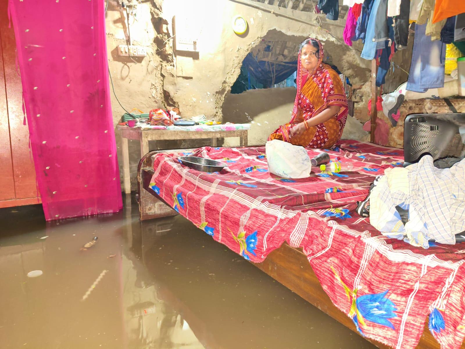 0ce00740-44e3-4040-bab3-c6b8b0eb92f5_a_woman_sitting_on_a_cot_at_the_waterlogged_Balisahi_near_Paradip.jpg