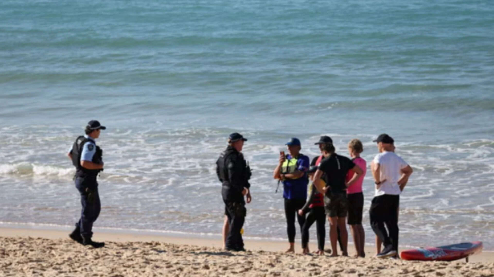 Police speak to people at the scene of the shark attack. (Reuters photo)