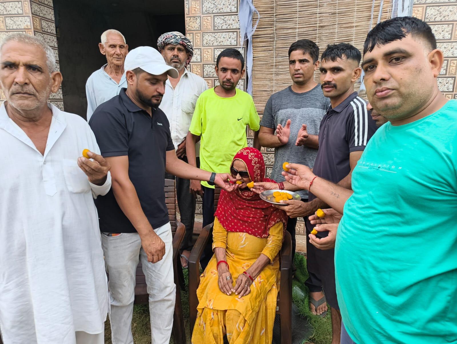 Sharmila Dhankar's mother and other family members celebrate at their Mahendragarh home on Wednesday.jpeg