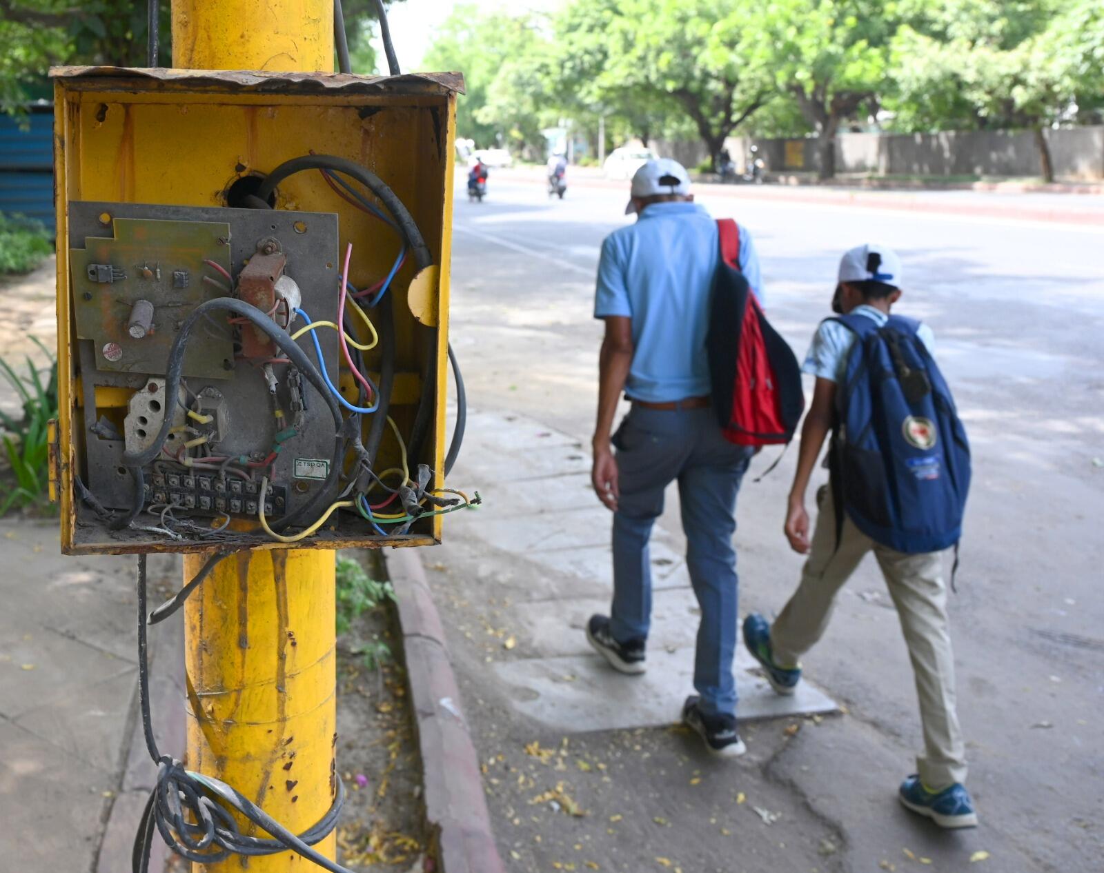 Open, live electrical boxes on pedestrian pathways