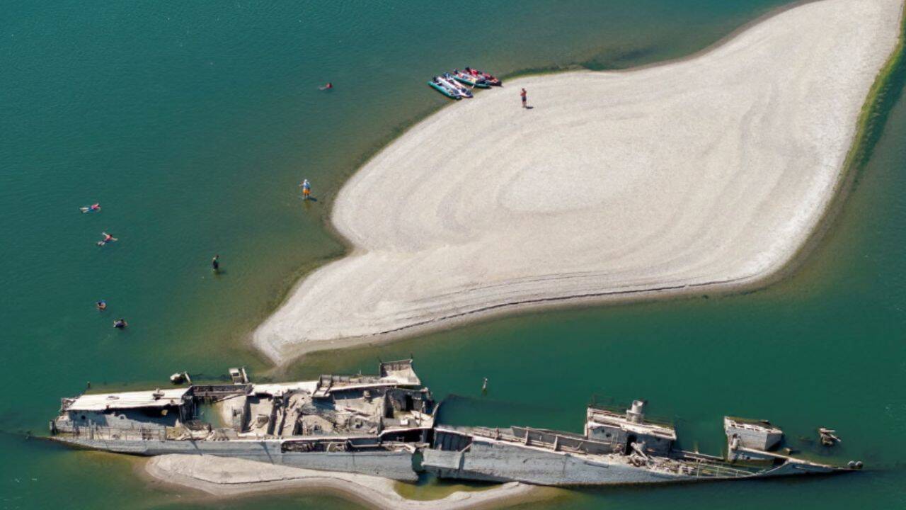 People swimming near a sunken German warship in Prahovo, Serbia. (Photo: The Guardian)<br>