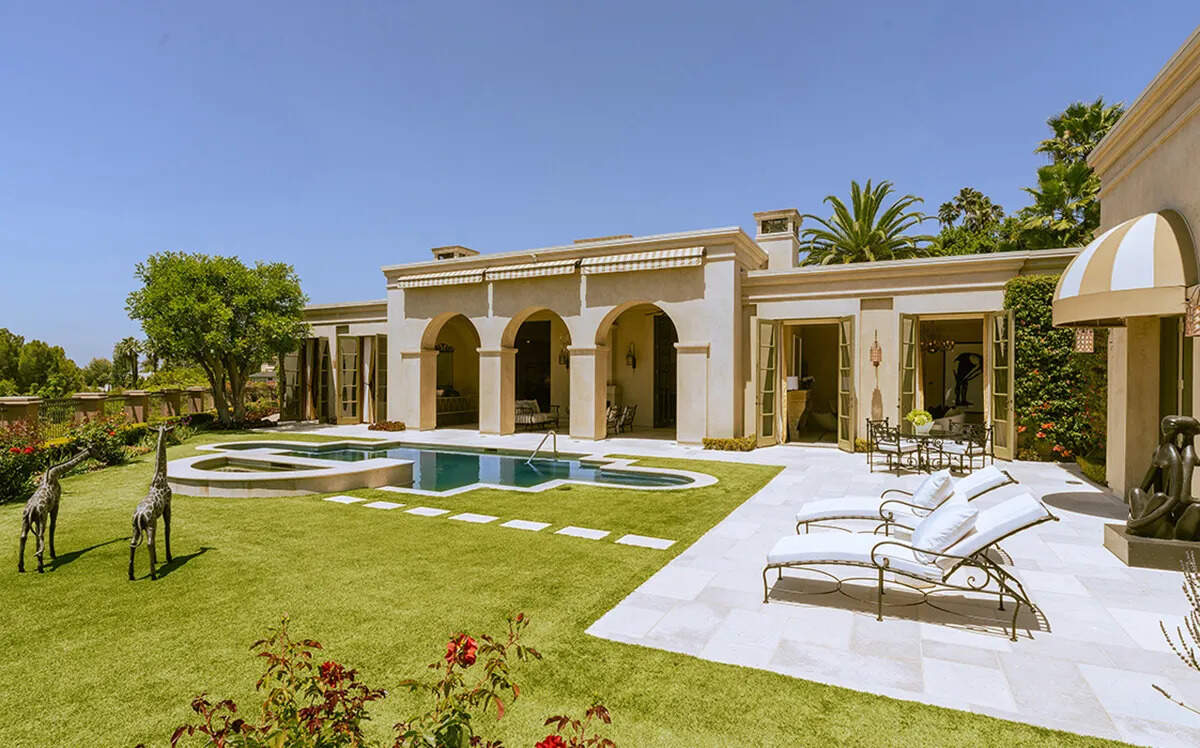 The nearly one-acre grounds include a freeform pool, spillover spa, sundeck and manicured lawns.