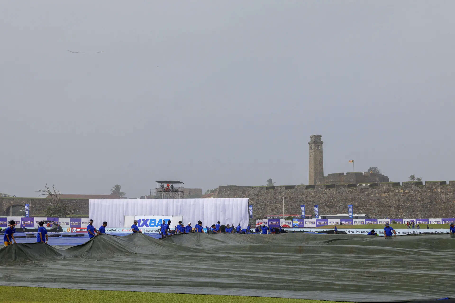 Galle [Sri Lanka], Aug 15 (ANI): Ground staff cover the ground as it rains durin...