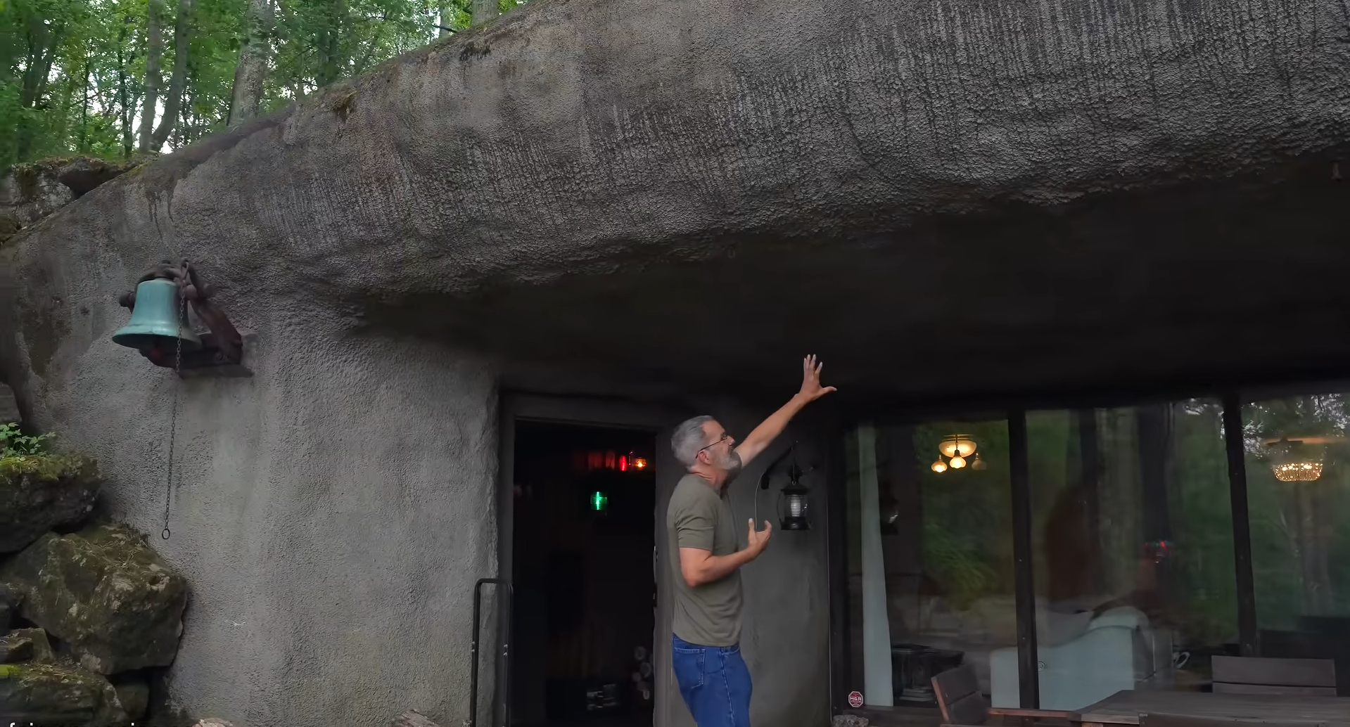 A cave-inspired entrance: A huge glass wall allows natural light into the home while creating the feel of a cave opening.