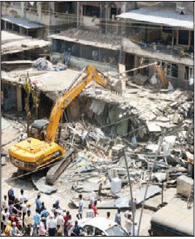 A JCB pulls down the illegal constructions in Mumbra, Kausa. 