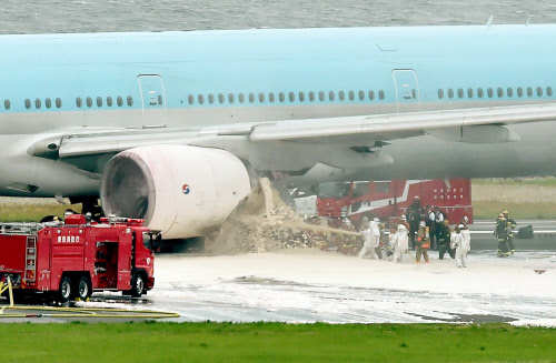 Firefighters extinguish at an engine of a Korean Air Boeing 777 on a runway in Tokyo's Haneda Airport. (AFP photo)