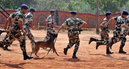 A Belgian Shepherd Dog (Malinois) runs with its handler amongst Central Police Reserve Force commandos to display the dog's agility during the inauguration of CRPF's Dog breeding and training school on the outskirts of Bangalore.