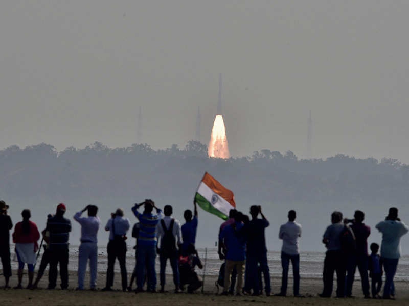 People watch as a rocket from Space agency Indian Space Research Organisation (ISRO) takes off successfully to launch a record 104 satellites. PTI photo